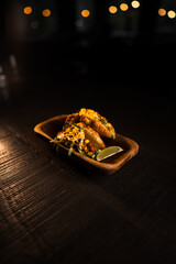 Taco with lime and vegetables in a plate on a black background.Mexican cuisine concept