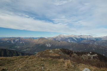vista panoramica che guarda dalla cima del Monte Matajur verso varie catene montuose nella Slovenia occidentale, sotto un cielo nuvoloso, di giorno, in autunno
