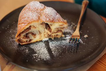 vista macro di una fetta di gubana, dolce tradizionale del Friuli Venezia Giulia, su un piatto scuro