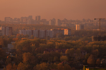 Evening view of the city. Sunset orange sky and beautiful cityscape, buildings and city streets,...