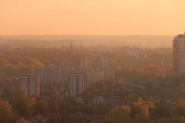 Evening view of the city. Sunset orange sky and beautiful cityscape, buildings and city streets,...