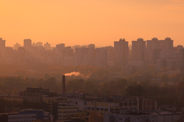 Evening view of the city. Sunset orange sky and beautiful cityscape, buildings and city streets,...