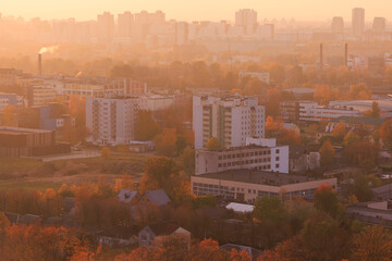 Evening view of the city. Sunset orange sky and beautiful cityscape, buildings and city streets,...
