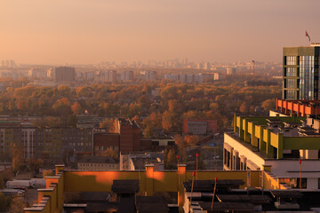 Evening view of the city. Sunset orange sky and beautiful cityscape, buildings and city streets, public place
