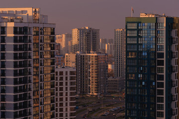 Evening view of the city. Sunset orange sky and beautiful cityscape, buildings and city streets, public place