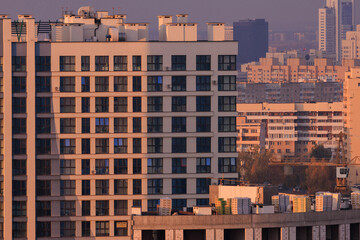 Evening view of the city. Sunset orange sky and beautiful cityscape, buildings and city streets,...