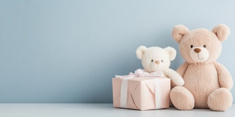 Two soft teddy bears next to a gift box, perfect for a cozy children's room decor.