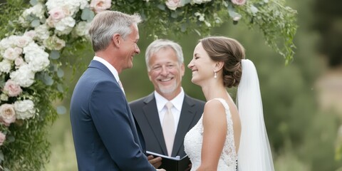 A joyful wedding ceremony featuring a couple exchanging vows with a smiling officiant and floral decoration.