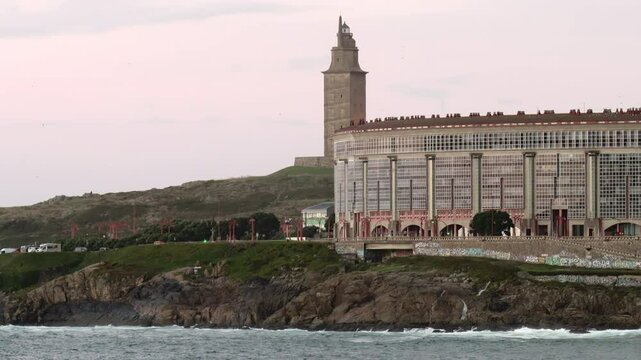 Tower of Hercules, lighthouse located in the Spanish city of A Coru&ntilde;a on a day with typical Galician weather with fog and rain with the sea hitting the rocks on which it is located