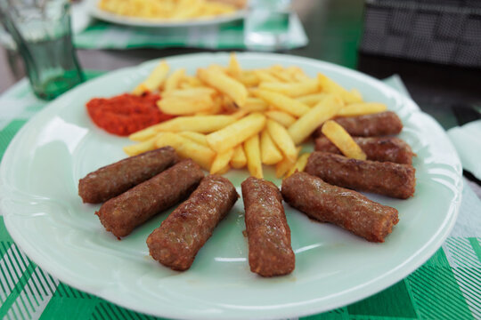 piatto con cevapcici, cibo tradizionale sloveno a base di carne, e patatine fritte con salsa ajvar