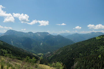 vista panoramica frontale in alta quota su di un ambiente naturale nelle Alpi Italiane a nord-est, con tante catene montuose che si estendono verso l'orizzonte, nella foschia, di mattina, in primavera