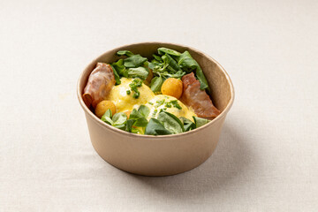 Eggs benedict with bacon and salad