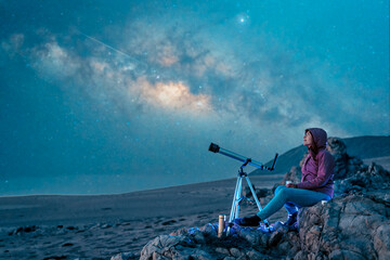 woman sitting in the desert alone contemplating the starry sky and the milky way in the background
