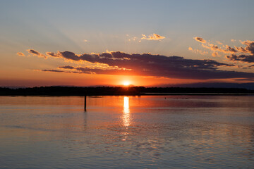 vista panoramica di un bellissimo tramonto su una laguna Veneta, col mare calmo, in estate ed il...