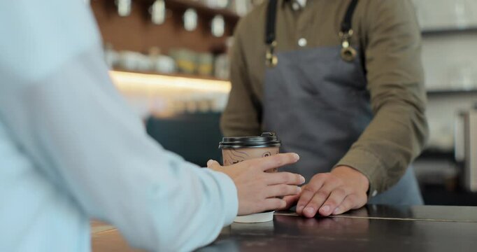 Close up of hands of barista man and client woman. Barista handing coffee to caucasian female. Passing coffee-to-go at counter. Giving ordered drink. Coffee house. Coffee to go.