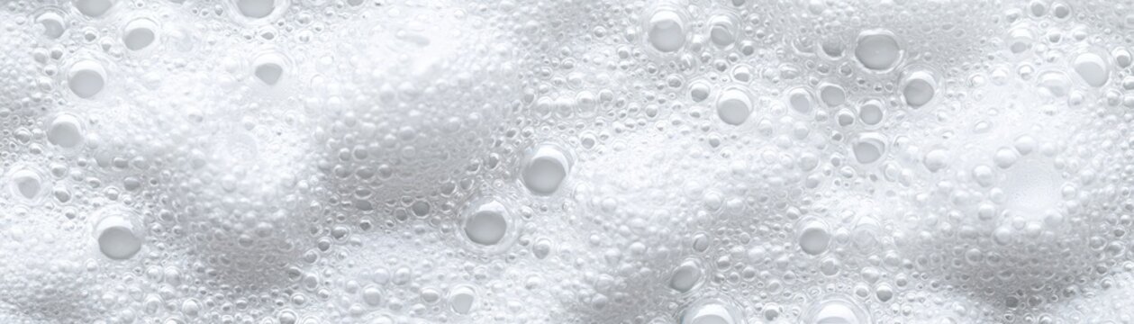 Close-up of white bubbles on a smooth surface, creating a refreshing and clean background ideal for various design projects.
