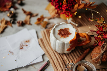 Autumn composition of spice Latte, cookies and fall leaves on the table.
