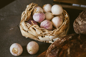 Garlic in a wicker basket on a dark background