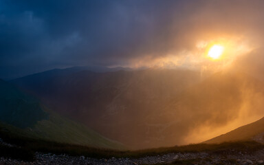 Colorful foggy and cloudy sunset in the mountains