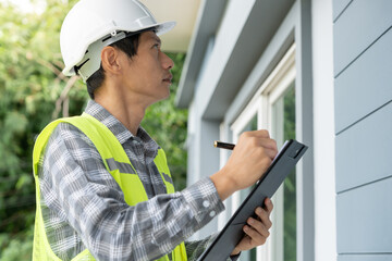 inspector or engineer is inspecting construction and quality assurance new house using a checklist. Engineers or architects or contactor work to build the house before handing it over to the homeowner