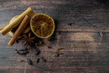 spices for tea cinnamon, star anise, cloves, orange, and glen wine on a dark wooden background top view