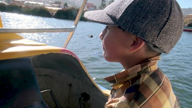 vertical latin boy driving a boat on a lake titicaca in daylight in la paz bolivia - adventure concept