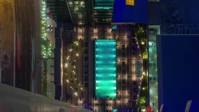DOHA, QATAR - OCTOBER 25, 2024: Aerial view of a stunning illuminated pool surrounded by modern architecture at night