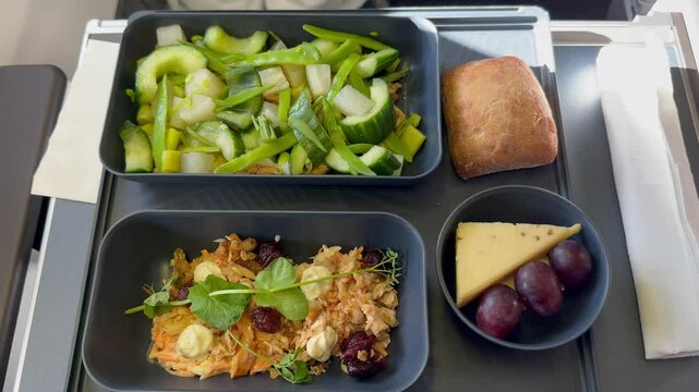 Flight meal - Appetizer Pulled BBQ chicken with coleslaw, Side dish of moulin blue, Cumin cheese and grapes and Main dish Asian style chicken salad with vegetables served in sustainable tableware