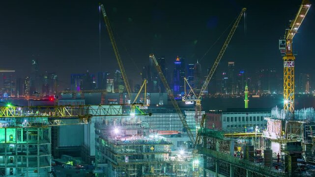 DOHA, QATAR - OCTOBER 25, 2024: Nighttime construction site with cranes and city skyline highlighting Qatar's development progress