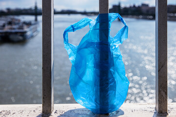 Blue Plastic bag hanging on the railing of Elisabeth bridge over Donau river in Budapest. Problem...