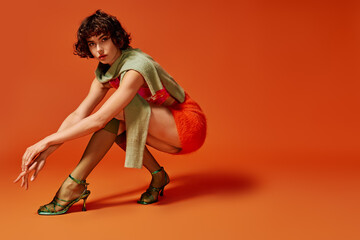 The young woman displays a range of emotions, posed artistically in an orange backdrop.