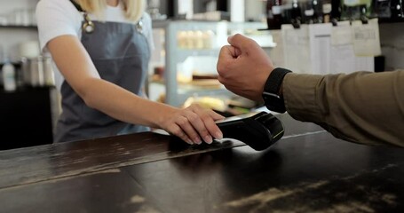 Close up customer for takeaway coffee paying with an NFC contactless smartwatch with a card machine. Paying in a coffee shop by a smartwatch. Technology. - Powered by Adobe