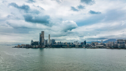 Naklejka premium A cloudy day over the skyline of Hong Kong reflecting on the calm harbor waters