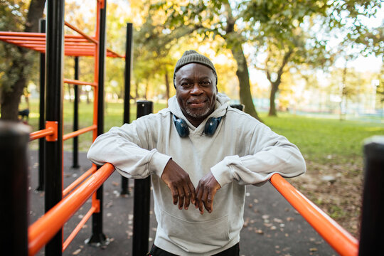 Portrait of a senior man exercising at outdoor fitness park in autumn