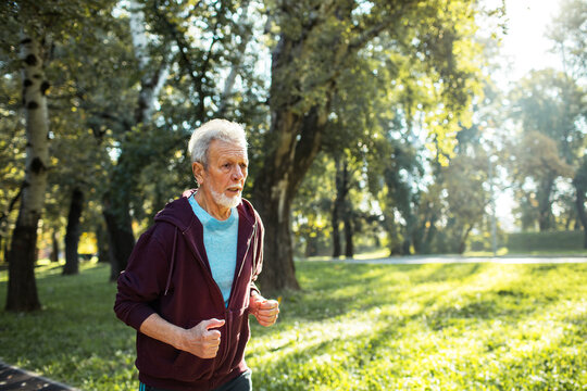 Smiling senior man jogging in the park