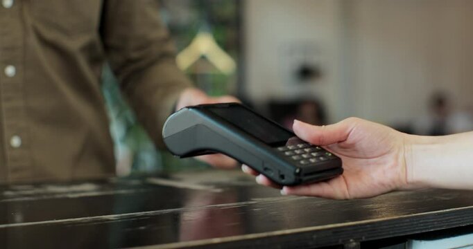 Man hand with smartwatch using terminal for payment in coffee shop, non-cash transaction, side view. Non-cash payment concept. Pos-terminal on table on black background.