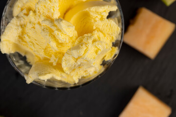 sweet creamy ice cream and pieces of melon on the table