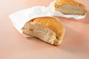 A view of a piece of coco bread in a paper bag.
