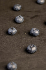 blueberries scattered on a black slate board