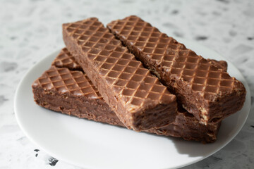 A view of a pile of chocolate wafer bars, on a plate.
