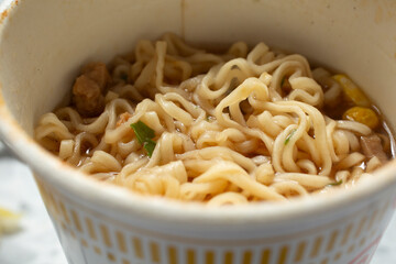 A closeup view of instant ramen noodles in a package cup, as a background.