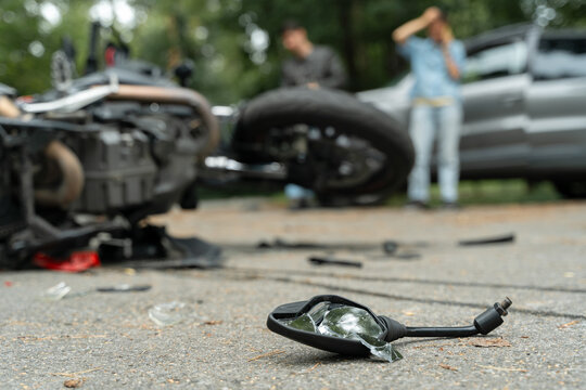 Damaged motorbike and car on the city road at the scene of an accident. Broken and wrecked motorcycle on road