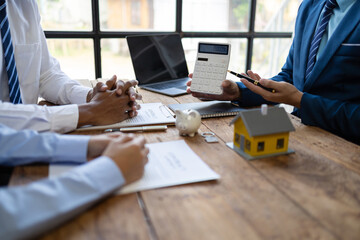 Businessman is offering a house price to a customer. Businessman, real estate agents discuss house...