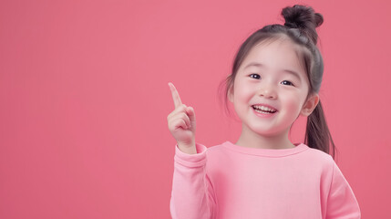 adorable little  korean girl pointing upwards, wearing pink sweater on a vibrant pink background, cheerful expression
