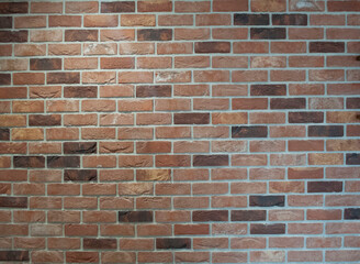 Colorful thin cut stone brick wall with streams of water running down the surface