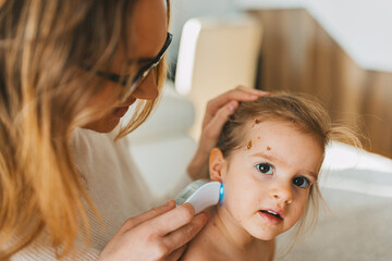 In a close-up scene, a mother checks a child's skin using a modern device, highlighting the themes...