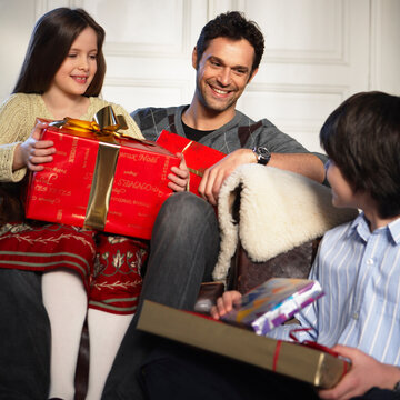 Father and Son and Daughter Holding Christmas Presents