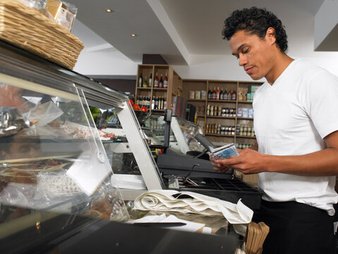 Man Counting Cash at Register