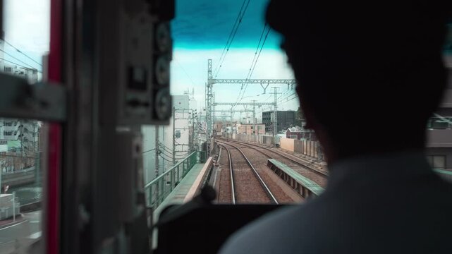 電車を運転する運転士と正面の景色