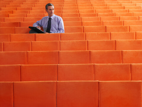Businessman Sitting in Auditorium